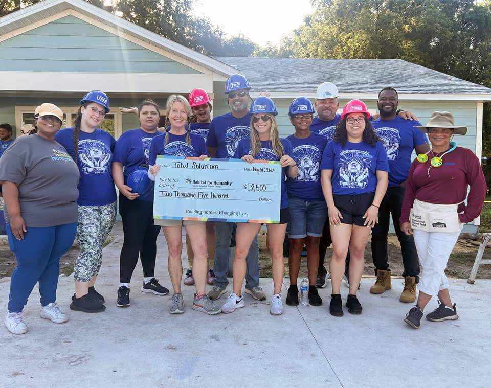TSG volunteers presenting a donation to Habitat for Humanity
